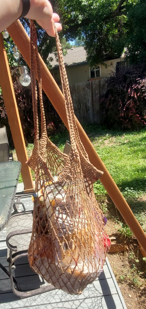 a picture of a crochet market bag that is made out of brown plastic grocery store bags